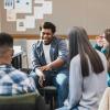 Young adults talk and laugh together while seated around a circle in an indoor group setting