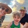 Jonathan and his family smile on a sandy beach