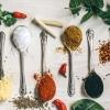 Five spoons filled with colorful spices on a table