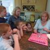 Sally and her children watch as her mother-in-law opens a gift.