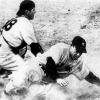 1950 black and white photo of catcher Phil Masi tagging Yogi Berra after sliding into base