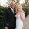 Brandon and Jackie on their wedding day beside a flowering tree